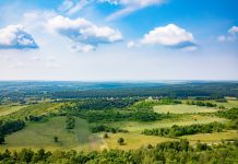 Experience a Breathtaking Panoramic View of a Lush Green Landscape with Beautiful Blue Skies